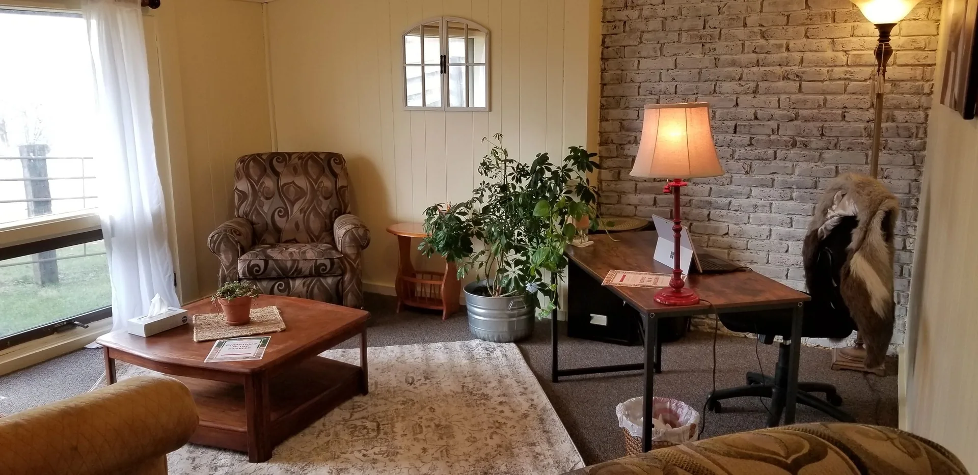 Comfortable chairs, soft lamplight, and a fireplace in the ranch’s counseling room
